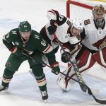 Arizona Coyotes' Jordan Oesterle, center, trips between Minnesota Wild's Mikael Granlund, left, of Finland and Coyotes goalie Antti Raanta, also of Finland, duirng the second period of an NHL hockey game Tuesday, Nov. 27, 2018, in St. Paul, Minn. (AP Photo/Jim Mone)