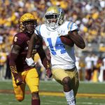 UCLA wide receiver Theo Howard (14) runs with the ball ahead of Arizona State defensive back Kobe Williams during the first half of an NCAA college football game, Saturday, Nov. 10, 2018, in Tempe, Ariz. (AP Photo/Ralph Freso)