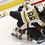 Boston Bruins right wing David Pastrnak (88) collides with Arizona Coyotes defenseman Jordan Oesterle (82) and Coyotes goaltender Darcy Kuemper, back right, during the first period of an NHL hockey game Saturday, Nov. 17, 2018, in Glendale, Ariz. (AP Photo/Ross D. Franklin)