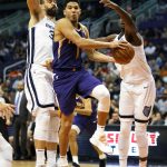 Phoenix Suns guard Devin Booker (1) drives between Memphis Grizzlies center Marc Gasol (33) and Jaren Jackson Jr. in the second half during an NBA basketball game, Sunday, Nov. 4, 2018, in Phoenix. The Suns defeated the Grizzlies 102-100. (AP Photo/Rick Scuteri)