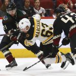 Boston Bruins left wing Brad Marchand (63) gets tripped up by Arizona Coyotes center Derek Stepan (21) and defenseman Dakota Mermis (43) during the third period of an NHL hockey game Saturday, Nov. 17, 2018, in Glendale, Ariz. The Bruins won 2-1. (AP Photo/Ross D. Franklin)
