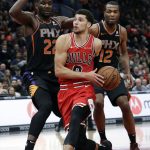 Chicago Bulls guard Zach LaVine (8) drives to the basket against Phoenix Suns center Deandre Ayton (22) and forward T.J. Warren (12) during the second half of an NBA basketball game Wednesday, Nov. 21, 2018, in Chicago. The Bulls won 124-116. (AP Photo/Nam Y. Huh)