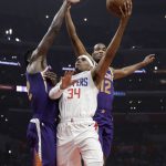 Los Angeles Clippers' Tobias Harris (34) shoots between Phoenix Suns' Deandre Ayton, left, and T.J. Warren (12) during the first half of an NBA basketball game Wednesday, Nov. 28, 2018, in Los Angeles. (AP Photo/Marcio Jose Sanchez)