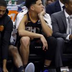 Phoenix Suns guard Devin Booker watches from the bench during the second half of the team's NBA basketball game against the Oklahoma City Thunder, Saturday, Nov. 17, 2018, in Phoenix. Oklahoma City won 110-100. (AP Photo/Rick Scuteri)