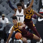 Arizona State's Remy Martin falls to the ground while driving against Utah State's Tauriawn Knight during the first half of an NCAA college basketball game Wednesday, Nov. 21, 2018, in Las Vegas. (AP Photo/John Locher)
