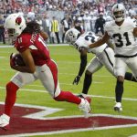 Arizona Cardinals wide receiver Larry Fitzgerald (11) scores a touchdown as Oakland Raiders strong safety Marcus Gilchrist (31) and cornerback Nick Nelson (23) defend during the first half of an NFL football game, Sunday, Nov. 18, 2018, in Glendale, Ariz. (AP Photo/Ross D. Franklin)