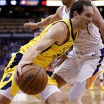 Indiana Pacers forward Bojan Bogdanovic fouls Phoenix Suns guard Devin Booker, right, as he drives to the basket during the first half of an NBA basketball game, Tuesday, Nov. 27, 2018, in Phoenix. (AP Photo/Matt York)