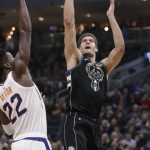 Milwaukee Bucks' Brook Lopez, right, shoots as Phoenix Suns' Deandre Ayton defends during the first half of an NBA basketball game Friday, Nov. 23, 2018, in Milwaukee. (AP Photo/Jeffrey Phelps)