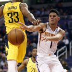 Phoenix Suns guard Devin Booker (1) dishes around Indiana Pacers center Myles Turner (33) during the second half of an NBA basketball game, Tuesday, Nov. 27, 2018, in Phoenix. The Pacers won 109-104. (AP Photo/Matt York)