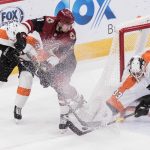 Arizona Coyotes' Brendan Perlini (11) and the Philadelphia Flyers' Ivan Provorov (9) and goalie Calvin Pickard (33) fight for the puck during the second period of an NHL hockey game Monday, Nov. 5, 2018, in Glendale, Ariz. (AP Photo/Darryl Webb)