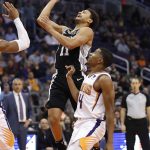San Antonio Spurs guard Bryn Forbes (11) is fouled by Phoenix Suns guard De'Anthony Melton, right, during the first half of an NBA basketball game, Wednesday, Nov. 14, 2018, in Phoenix. (AP Photo/Matt York)