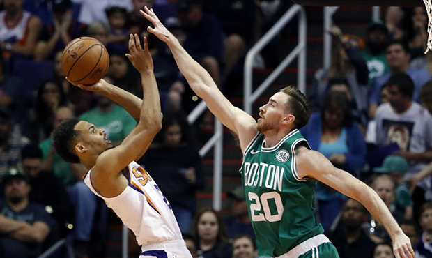 Phoenix Suns guard Elie Okobo, left, shoots over Boston Celtics forward Gordon Hayward (20) during ...
