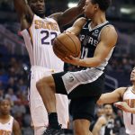San Antonio Spurs guard Bryn Forbes (11) tries to dish around Phoenix Suns center Deandre Ayton (22) during the first half of an NBA basketball game, Wednesday, Nov. 14, 2018, in Phoenix. (AP Photo/Matt York)