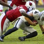 Oakland Raiders quarterback Derek Carr (4) is sacked by Arizona Cardinals defensive end Zach Moore (56) during the first half of an NFL football game, Sunday, Nov. 18, 2018, in Glendale, Ariz. (AP Photo/Ross D. Franklin)