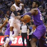 Orlando Magic guard Terrence Ross passes the ball around Phoenix Suns center Deandre Ayton (22) during the first half of an NBA basketball game Friday, Nov. 30, 2018, in Phoenix. (AP Photo/Rick Scuteri)