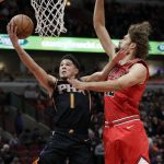 Phoenix Suns guard Devin Booker, left, drives to the basket as Chicago Bulls center Robin Lopez guards during the first half of an NBA basketball game Wednesday, Nov. 21, 2018, in Chicago. (AP Photo/Nam Y. Huh)