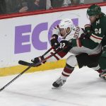 Minnesota Wild's Mikael Granlund, right, of Finland, tries to slow Arizona Coyotes' Jordan Oesterle during the first period of an NHL hockey game Tuesday, Nov. 27, 2018, in St. Paul, Minn. (AP Photo/Jim Mone)