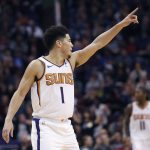Phoenix Suns guard Devin Booker (1) points to a teammate after a basket during the second half of an NBA basketball game against the San Antonio Spurs, Wednesday, Nov. 14, 2018, in Phoenix. (AP Photo/Matt York)