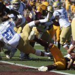 UCLA running back Joshua Kelley (27) dives into the end zone over Arizona State defensive back Chase Lucas (24) for a touchdown during the first half of an NCAA college football game, Saturday, Nov. 10, 2018, in Tempe, Ariz. (AP Photo/Ralph Freso)