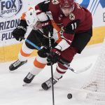 Arizona Coyotes' Brendan Perlini (11) and the Philadelphia Flyers' Ivan Provorov (9) mix it up behind the net during the second period of an NHL hockey game Monday, Nov. 5, 2018, in Glendale, Ariz. (AP Photo/Darryl Webb)