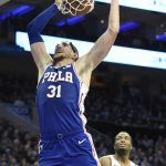 Philadelphia 76ers' Mike Muscala (31) dunks the ball as Phoenix Suns' TJ Warren (12) looks on in second half of an NBA basketball game, Monday, Nov. 19, 2018, in Philadelphia. The 76ers beat the Suns 119-114. (AP Photo/Michael Perez)