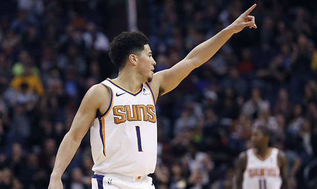Phoenix Suns guard Devin Booker (1) points to a teammate after a basket during the second half of a...