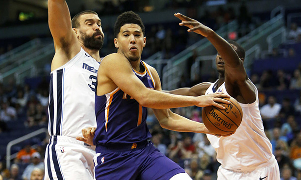 Phoenix Suns guard Devin Booker (1) drives between Memphis Grizzlies center Marc Gasol (33) and Jar...