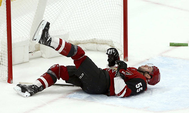 Injured Arizona Coyotes defenseman Jason Demers (55) pauses on the ice after colliding with the pos...