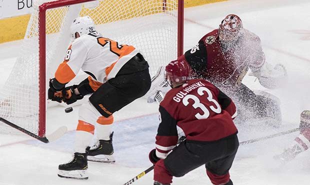 Philadelphia Flyers' Claude Giroux puts the puck in the net against the Arizona Coyotes goalie Darc...