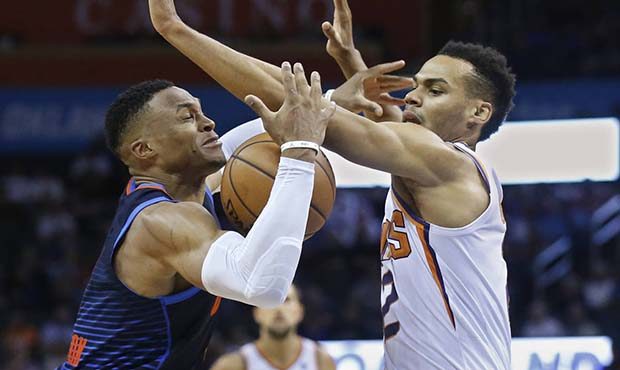 Oklahoma City Thunder guard Russell Westbrook, left, loses control of the ball after a foul by Phoe...