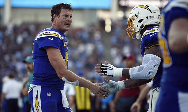 Los Angeles Chargers quarterback Philip Rivers, left, celebrates after throwing a touchdown pass ag...