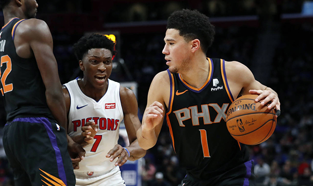 Phoenix Suns guard Devin Booker (1) is defended by Detroit Pistons forward Stanley Johnson (7) duri...