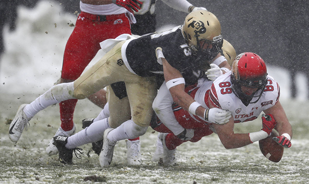 Utah tight end Cole Fotheringham, right, is tackled by Colorado defensive back Kyle Trego in the fi...