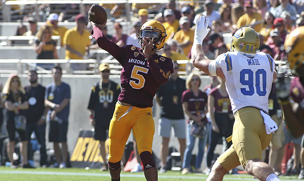 Arizona State quarterback Manny Wilkins (5) throws a pass while pressured by UCLA defensive end Ric...