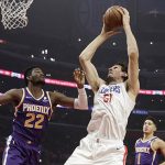 Los Angeles Clippers' Boban Marjanovic (51) grabs a rebound next to Phoenix Suns' Deandre Ayton (22) during the first half of an NBA basketball game Wednesday, Nov. 28, 2018, in Los Angeles. (AP Photo/Marcio Jose Sanchez)