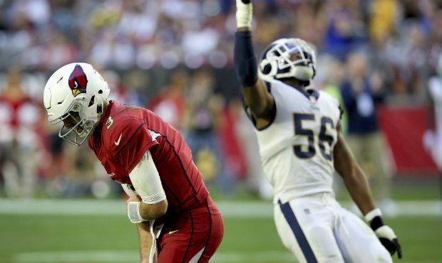 Arizona Cardinals quarterback Josh Rosen grabs his elbow after taking a hit from Los Angeles Rams l...