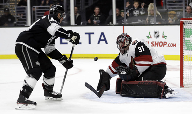 Arizona Coyotes goaltender Adin Hill (31) stops a shot from Nate Thompson, left, during the second ...