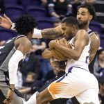 Phoenix Suns' Josh Jackson (20) gets double-teamed by Sacramento Kings' Willie Cauley-Stein (00) and De'Aaron Fox (5) during the first half of an NBA basketball game, Tuesday, Dec. 4, 2018, in Phoenix. (AP Photo/Darryl Webb)