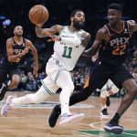 Boston Celtics guard Kyrie Irving (11) passes the ball as he drives against Phoenix Suns center Deandre Ayton (22) during the second quarter of a basketball game in Boston, Wednesday, Dec. 19, 2018. (AP Photo/Charles Krupa)