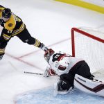Arizona Coyotes goaltender Darcy Kuemper, right, sweeps his stick as he tries to break up a drive to the net by Boston Bruins center Ryan Donato (17) during the first period of hockey game in Boston, Tuesday, Dec. 11, 2018. (AP Photo/Charles Krupa)