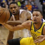 Golden State Warriors guard Stephen Curry, right, and Phoenix Suns forward Mikal Bridges vie for the ball during the first half of an NBA basketball game Monday, Dec. 31, 2018, in Phoenix. (AP Photo/Rick Scuteri)