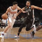 Brooklyn Nets' Spencer Dinwiddie (8) defends against Phoenix Suns' Devin Booker (1) during the first half of an NBA basketball game Sunday, Dec. 23, 2018, in New York. (AP Photo/Frank Franklin II)