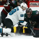 San Jose Sharks center Melker Karlsson (68) battles with Arizona Coyotes right wing Mario Kempe (29) as Coyotes goaltender Adin Hill (31) looks for the puck during the second period of an NHL hockey game, Saturday, Dec. 8, 2018, in Phoenix. (AP Photo/Ross D. Franklin)