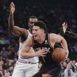 Phoenix Suns' Devin Booker (1) drives past New York Knicks' Noah Vonleh during the first half of an NBA basketball game Monday, Dec. 17, 2018, in New York. (AP Photo/Frank Franklin II)