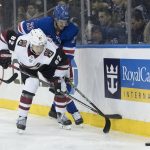 Arizona Coyotes defenseman Jordan Oesterle (82) fights for the puck against New York Rangers center Brett Howden (21) during the second period of an NHL hockey game, Friday, Dec. 14, 2018, at Madison Square Garden in New York. (AP Photo/Mary Altaffer)