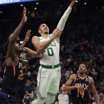Boston Celtics forward Jayson Tatum (0) drives to the basket past Phoenix Suns guard De'Anthony Melton (14) and center Deandre Ayton, left, during the first quarter of a basketball game in Boston, Wednesday, Dec. 19, 2018. (AP Photo/Charles Krupa)