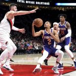 Phoenix Suns guard Elie Okobo, center, gives a head fake to Portland Trail Blazers center Jusuf Nurkic, left, as Trail Blazers guard Seth Curry, right center, and Suns forward Richaun Holmes, right, defend during the first half of an NBA basketball game in Portland, Ore., Thursday, Dec. 6, 2018. (AP Photo/Steve Dykes)