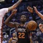 Phoenix Suns center Deandre Ayton (22) loses control of the ball as drives between Miami Heat's Tyler Johnson (8) and Kelly Olynyk (9) during the second half of an NBA basketball game Friday, Dec. 7, 2018, in Phoenix. The Heat defeated the Suns 115-98. (AP Photo/Rick Scuteri)