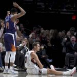 Portland Trail Blazers forward Jake Layman, right, sits on the court after hitting a three-point basket over Phoenix Suns guard De'Anthony Melton, left, during the first half of an NBA basketball game in Portland, Ore., Thursday, Dec. 6, 2018. (AP Photo/Steve Dykes)