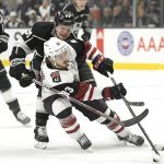 Los Angeles Kings left wing Austin Wagner, top, reaches for the puck in front of Arizona Coyotes right wing Conor Garland during the first period of an NHL hockey game Thursday, Dec. 27, 2018, in Los Angeles. (AP Photo/Mark J. Terrill)